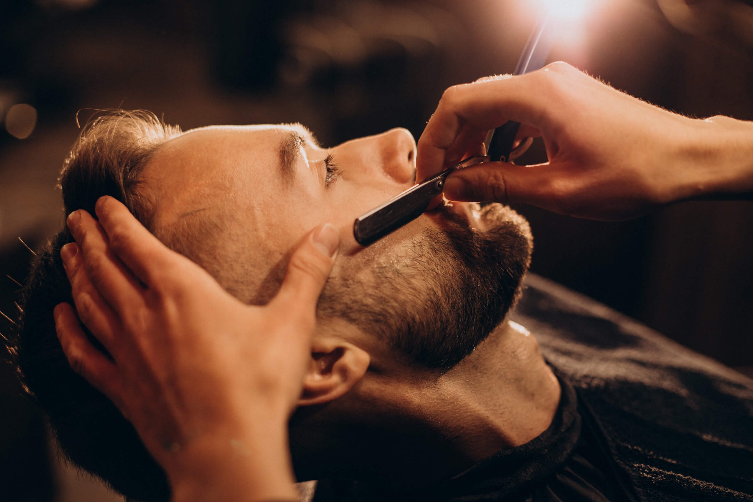 barber shaving the beard of a handsome man from rebel barber