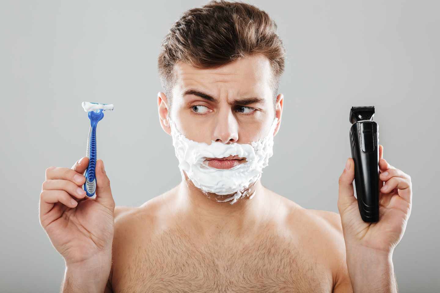 man choosing what to trim his beard with